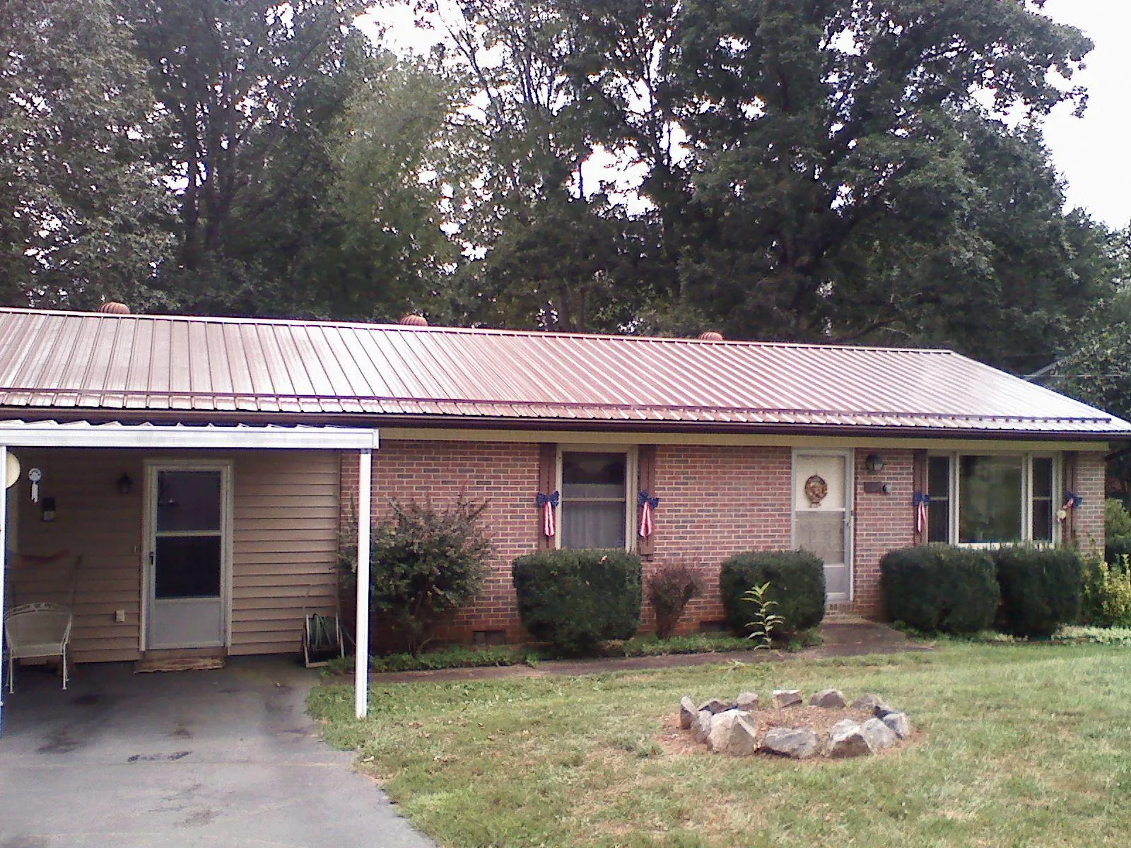Bronze metal roof and carport on a brick ranch home — Roof Repair work by our crew in Michie